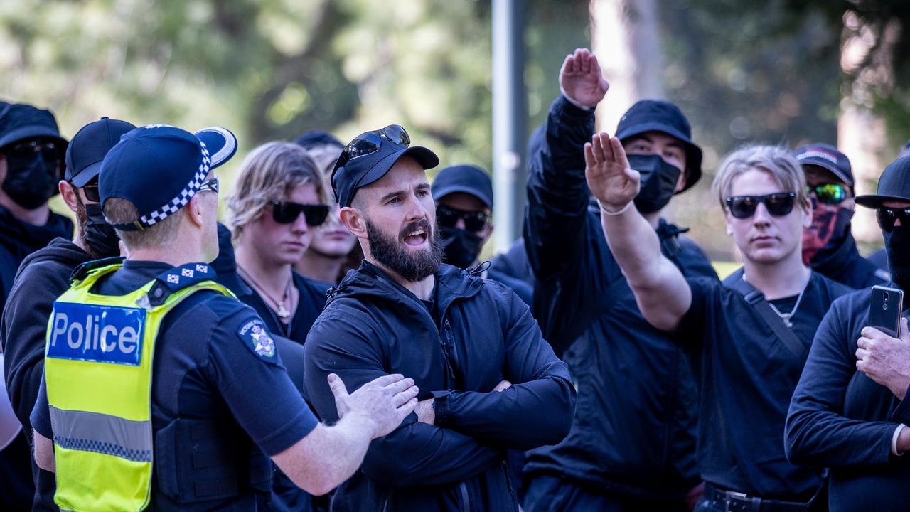 Thomas Sewell speaks with police while members display the Nazi salute. Picture: Jake Nowakowski