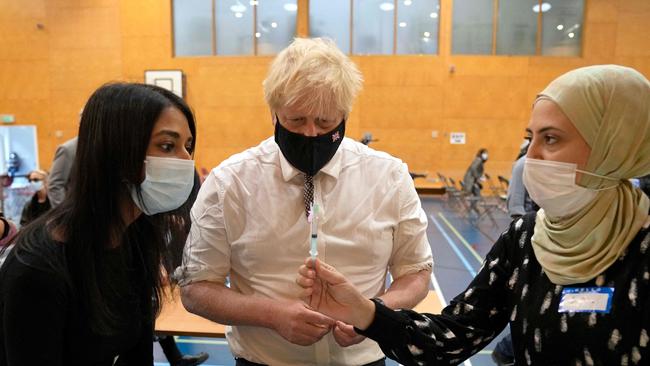 British Prime Minister Boris Johnson watches as staff prepare doses of the Pfizer-BioNTech vaccineat Little Venice Sports Centre in London. The UK is pushing over-50s and clinically vulnerable to take up the offer of a third booster vaccine. Picture: AFP