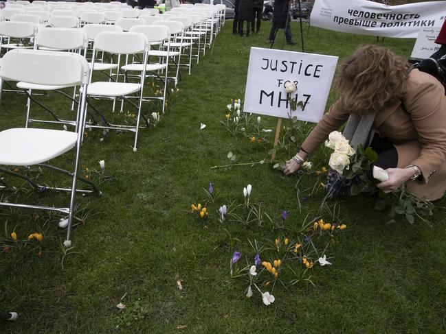 A woman places a rose next to 298 empty chairs, each chair for one of the 298 victims of downed Malaysia Air flight MH17, near The Hague. Picture: AP