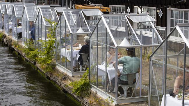 Customers seated in small glasshouses to enforce distancing enjoy lunch at the Mediamatic restaurant in Amsterdam, Netherlands. Picture: Peter Dejong/AP