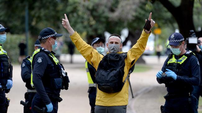 Police speak to a demonstrator at the anti-lockdown protest on The Tan. Picture: Andrew Henshaw