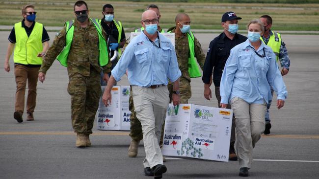 Australian officials carry boxes containing 8000 initial doses of the AstraZeneca vaccine at the Port Moresby international airport in Papua New Guinea on Tuesday. Picture: AFP