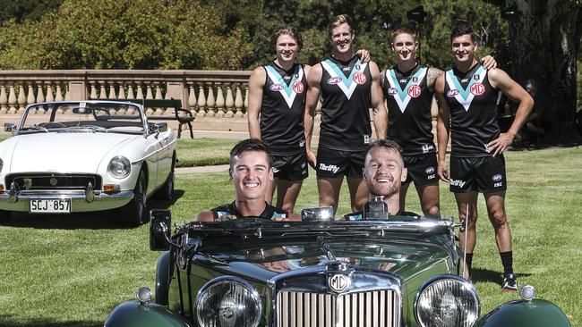 Connor Rozee and Robbie Gray (front, from left) in a historic MG with (back, from left) Xavier Duursma, Tom Jonas, Hamish Hartlett and Tom Rockliff promoting the new deal on Tuesday. Picture: Sarah Reed