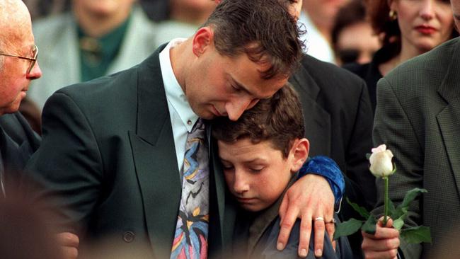 Walter Mikac with his nephew comfort each other at his family’s funeral.