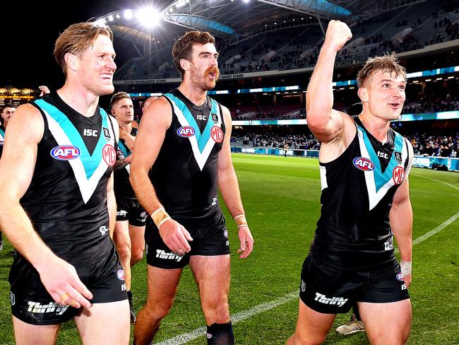 Ollie Wines, right, celebrates Port’s win over Richmond with Tom Jonas and Scott Lycett. Picture: Mark Brake/Getty Images