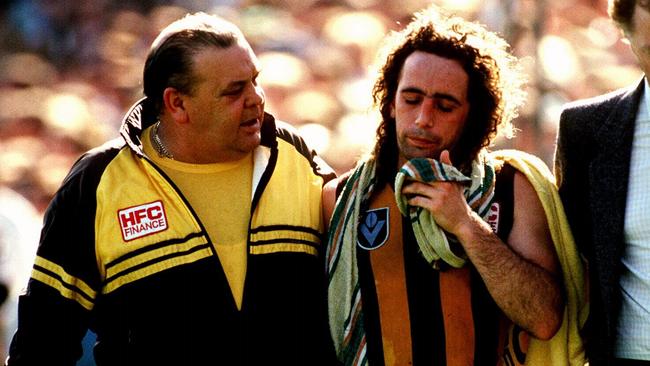 A concussed John Platten is taken back to the rooms during the 1989 Grand Final against Geelong.