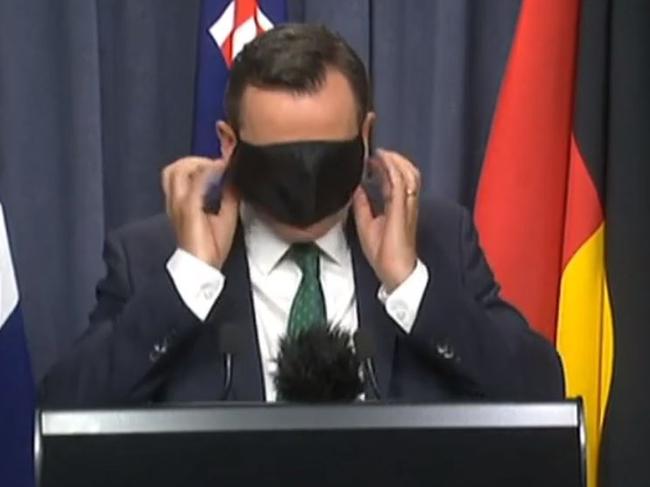 Premier of Western Australia, Mark McGowan struggles with his mask.