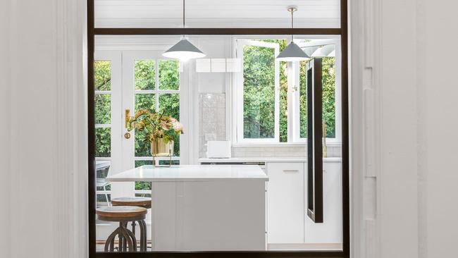 A glass door makes a feature of the kitchen and draws natural light to the centre of the home.