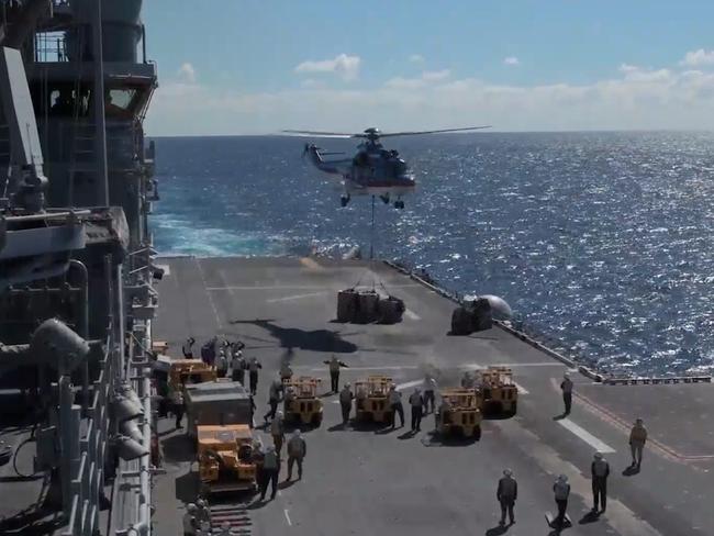 A helicopter delivers supplies to the deck of the USS America while it was off the coast of Queensland for Exercise Talisman Sabre 2021 in this still from a video. Picture: Supplied