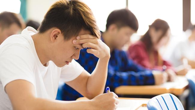 Stressed college student  for exam in classroom