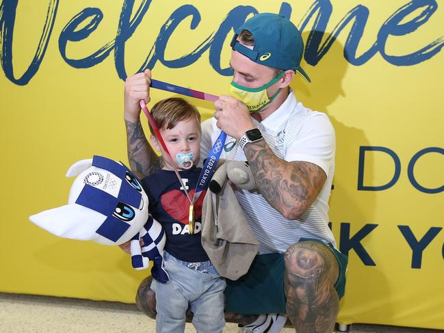 Logan Martin is reunited with his child after arriving back in Brisbane. (Photo by Jono Searle/Getty Images)