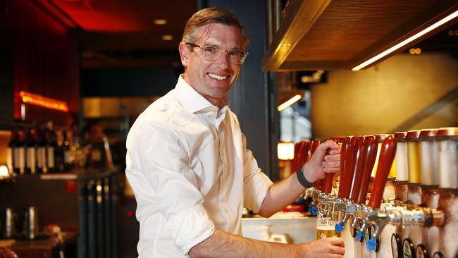 NSW Treasurer Dominic Perrottet celebrates the upcoming easing of restrictions at The Squire's Landing in The Rocks by pouring a beer. Picture: Sam Ruttyn