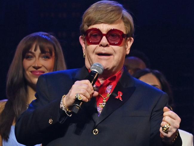 LONDON, ENGLAND - DECEMBER 01: (L to R) Shaina Taub, Sir Elton John and David Furnish speak on stage at "The Devil Wears Prada Musical" charity gala night in support of the Elton John Aids Foundation at The Dominion Theatre on December 1, 2024 in London, England. (Photo by Dave Benett/Getty Images for The Devil Wears Prada Musical)