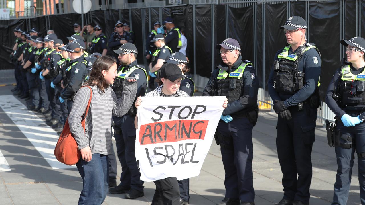 Police in front of the Melbourne Convention centre keep an eye on a few protesters the day before violent riots erupt. Picture: NewsWire/David Crosling