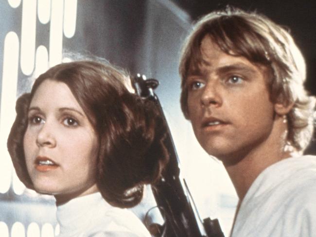 In this 1977 image provided by 20th Century-Fox Film Corporation, from left, Harrison Ford, Carrie Fisher, and Mark Hamill are shown in a scene from "Star Wars" movie released by 20th Century-Fox. Disney is previewing several of the studio's upcoming live-action films for fans at the D23 Expo, Aug. 9-11, 2013, a three-day Disney extravaganza at the Anaheim Convention Center. Disney bought George Lucas' Lucasfilm empire last year for $4.06 billion and plans to unleash a new "Star Wars" trilogy and two spin-off films beginning in 2015 with "Star Wars: Episode VII," which is being directed by J.J. Abrams and written by Michael Arndt. (AP Photo/20th Century-Fox Film Corporation)