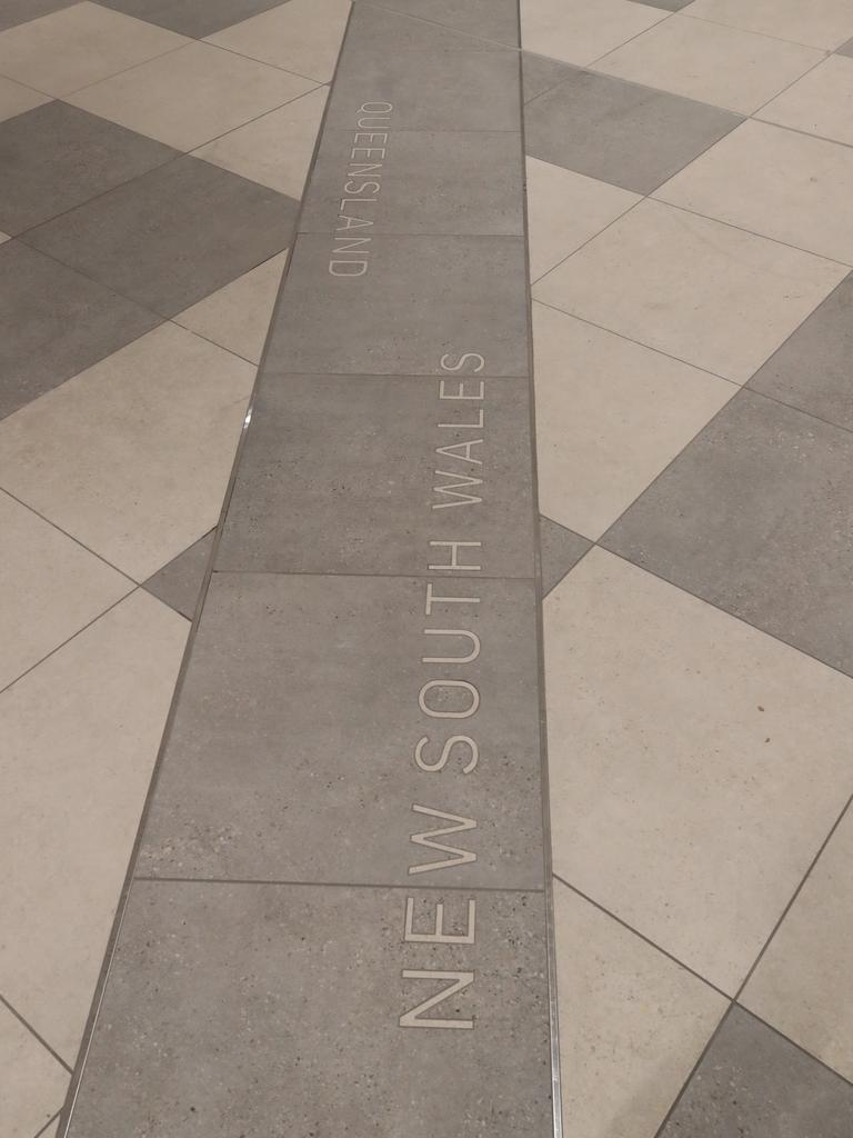 A line on the ground at the baggage reclaim area marking the border between QLD and NSW. Picture: Glenn Hampson.