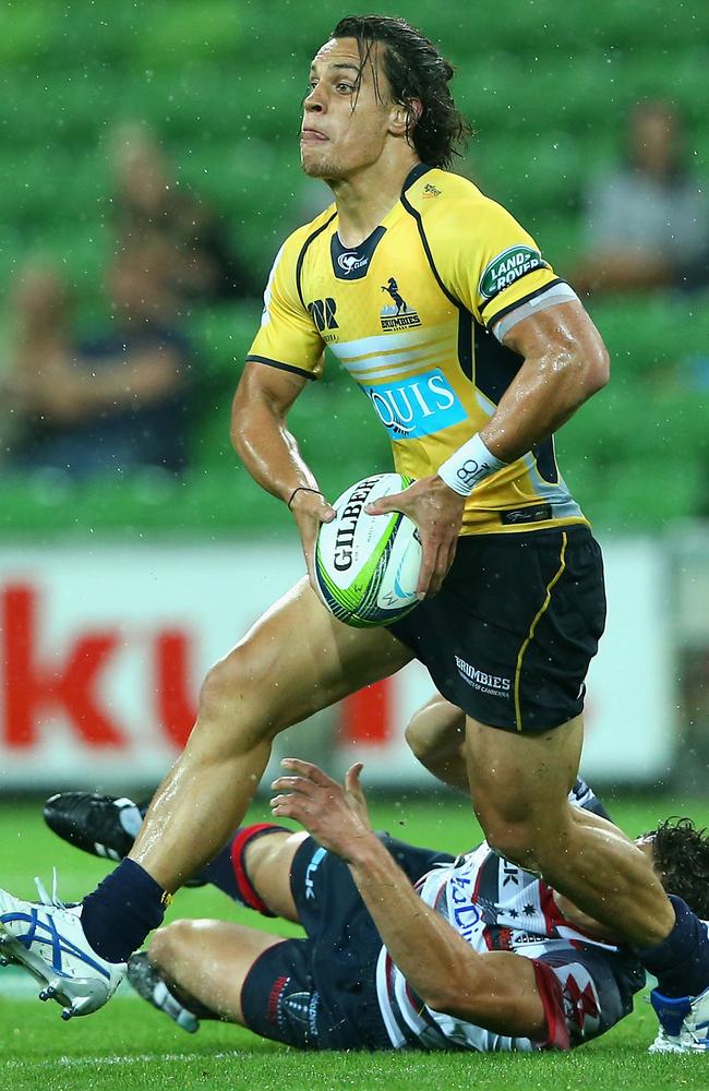 Matt Toomua of the Brumbies passes the ball while being tackled by Luke Burgess of the Rebels.