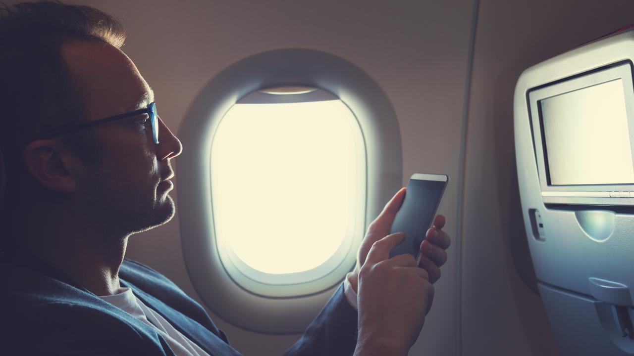 Man using smartphone in the aeroplane. Istock mobile phone plane