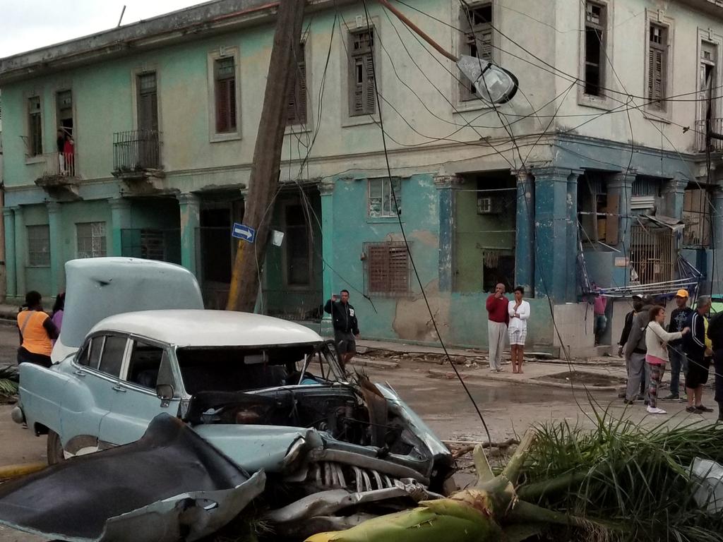 People survey the damage left behind by a tornado in Havana, Cuba, Monday, Jan. 28, 2019. A tornado and pounding rains smashed into the eastern part of Cuba's capital overnight, toppling trees, bending power poles and flinging shards of metal roofing through the air as the storm cut a path of destruction across eastern Havana. (AP Photo/Michael Weissenstein)