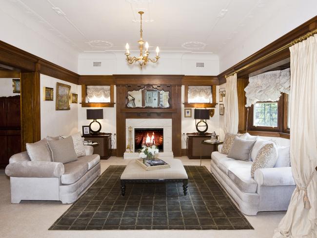 The formal living room has high ceilings, picture rails and a fireplace.