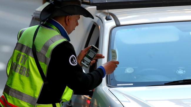 A parking ranger issues a ticket on Castlereagh St in Sydney’s CBD. Picture: Toby Zerna