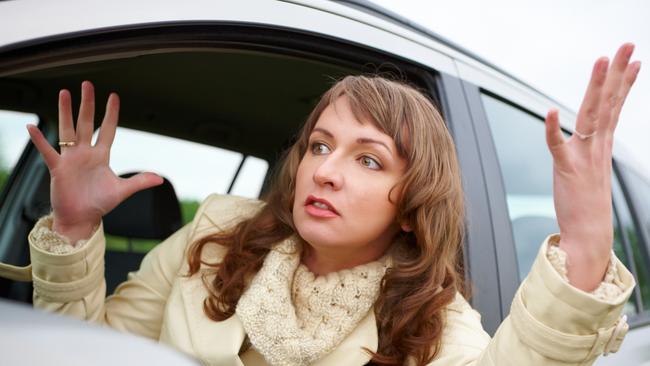 Angry young woman stuck in a traffic jam generic