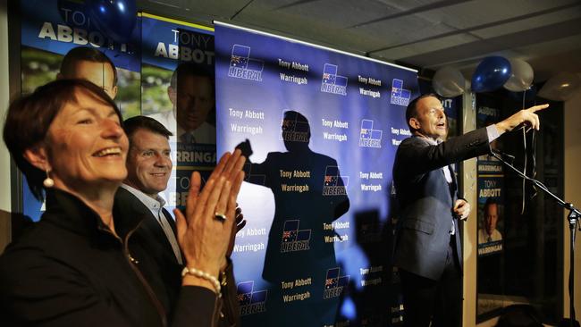 Tony Abbott points out his mum in the crowd during a speech with support of wife Margie, and NSW Premier Mike Baird on his election night party in Manly. Picture: Braden Fastier