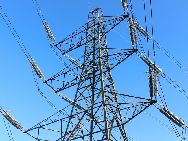 Photo showing a tall high-voltage transmission tower, which is known in the UK and much of Europe as an electricity pylon.  The photo shows a section of the tower, with wires, conductors and insulator strings.  This top part of the structure is named the 'peak', while the section beneath is the 'cage'.