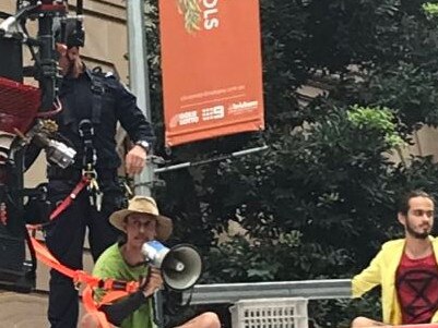 Firefighters work to remove activists from the top of a rental truck blocking traffic in the Brisbane CBD. Picture: Bianca Stone/7 News