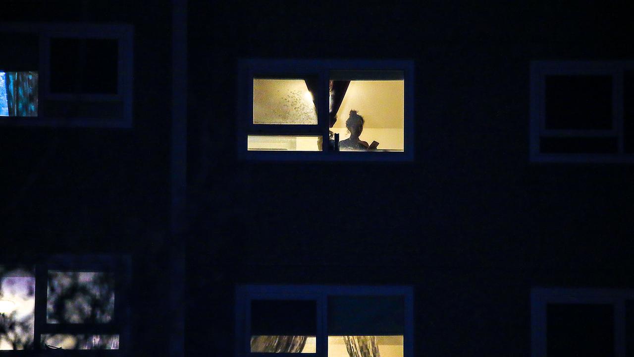 Public housing towers in North Melbourne (pictured) are now in immediate lockdown. A resident is pictured in their flat. Picture: Ian Currie