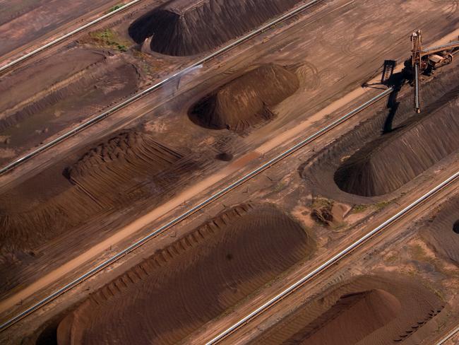 Iron ore awaits loading at BHP Billition Ltd.'s loading facility at Nelson Point in Pt. Hedland, Australia, on Wednesday, Jan. 21, 2008. BHP Billiton, the world's largest mining company, may take a $1.7 billion in one-time charges after closing a nickel mine in Australia and slashing 6,000 jobs as the global recession curbs demand for minerals. Photographer: Nelson Ching/Bloomberg News