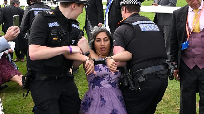 An animal rebellion activist is arrested after running onto the racecourse, on day two of the Epsom Derby. Picture: Getty.