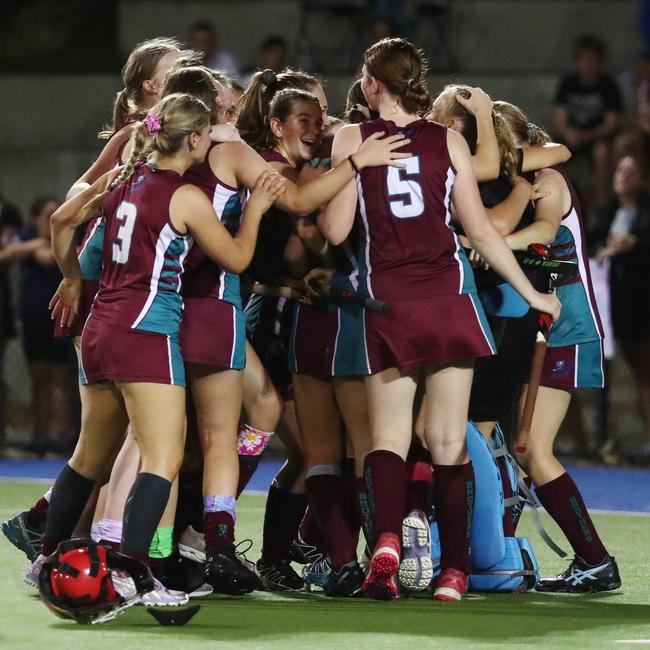 Brothers players rush in hug goal keeper Ella McLeod after she stopped a goal attempt by Saints' Talytha Macdonald to win the penalty shootout and the match for her team in the Cairns Hockey Association Under 18A Women's match between the Brothers Fury and the Cairns Saints. PICTURE: BRENDAN RADKE