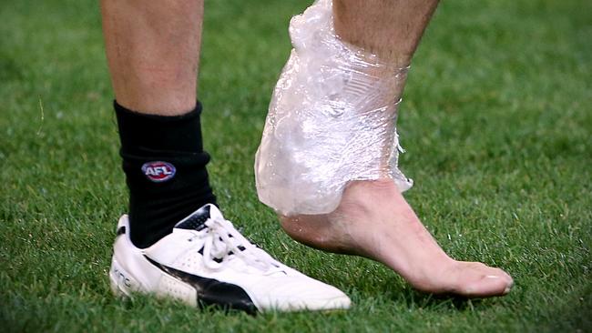 Scott Pendlebury’s ankle is iced up as he leaves the field. Picture: Wayne Ludbey