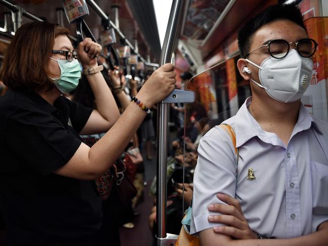 People wearing protective face masks ride the BTS Skytrain during their morning commute in Bangkok. Picture: Lillian Suwanrumpha/AFP