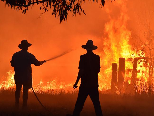TOPSHOT - Residents defend a property from a bushfire at Hillsville near Taree, 350km north of Sydney on November 12, 2019. - A state of emergency was declared on November 11 and residents in the Sydney area were warned of "catastrophic" fire danger as Australia prepared for a fresh wave of deadly bushfires that have ravaged the drought-stricken east of the country. (Photo by PETER PARKS / AFP)