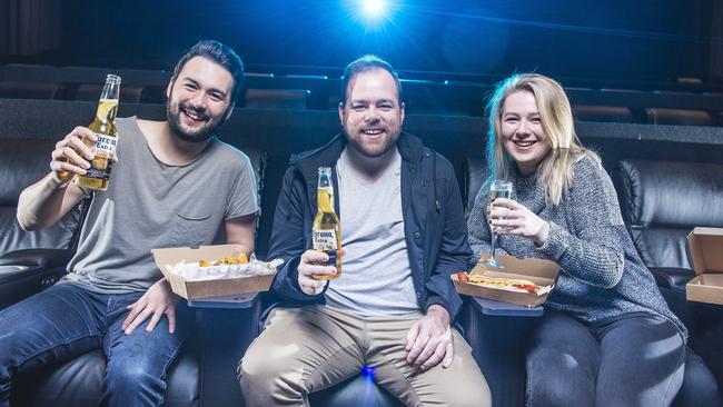 Mates Alvin Webster, Daniel Walker and Georgia Worswick enjoy the reclining chairs with food and drink in the cinema at Hoyts Eastland. Picture: Eugene Hyland