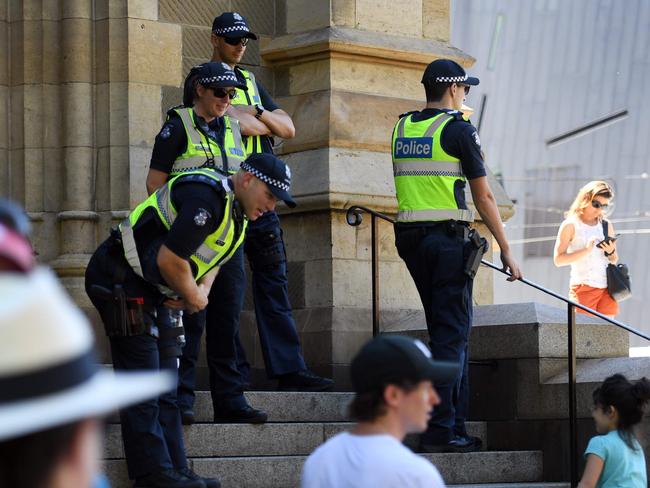 Victorian police officers stand guard outside St Paul's Cathedral in Melbourne after it was alleged to be one of three potential targets for terrorists on Christmas Day. Four people charged were among seven arrested on December 22 and 23. Picture: AFP / William West