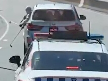 Two passengers shown on video taunting police with golf clubs on a busy freeway.