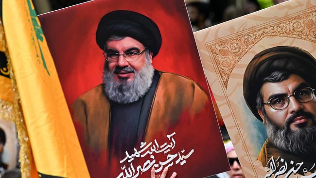 Demonstrators hold flags and pictures of Hassan Nasrallah, late leader of the terror group Hezbollah, at a protest rally in Sydney on Sunday. Picture: AFP