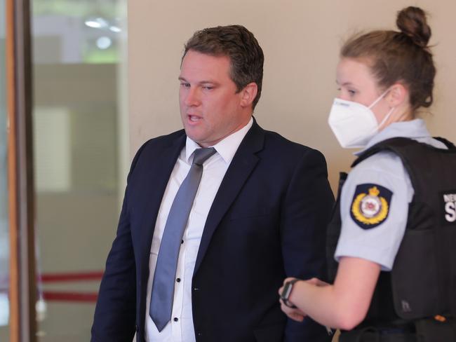 Former Reddam House teacher Ben Fenner, 35, and a police officer outside the Downing Centre in Sydney in October 2020. Picture: Christian Gilles