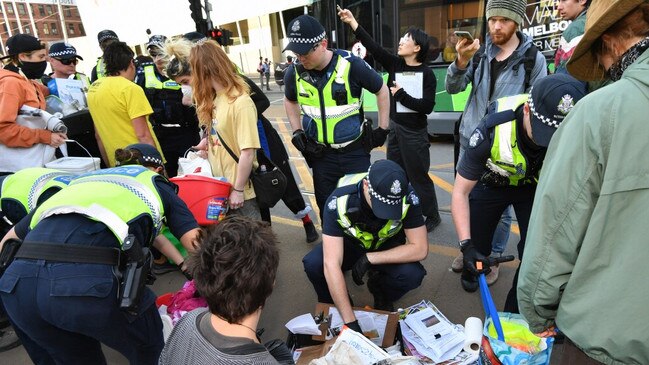 Police search protesters at the demonstration. Picture: Jake Nowakowski