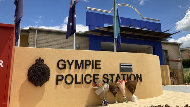 Gympie police station flags at half mast and bouquets of flowers had been placed out the front following the tragic events at the Darling Downs on Monday, where two officers and a member of the public were murdered by armed gunmen.