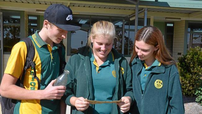 TIME CAPSULE: Tom Capewell, Elizabeth Strong and Karla White reading the message for the first time. Picture: Adam McCleery