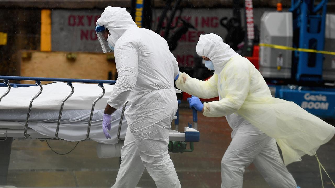 Medical personnel move a deceased patient to a refrigerated truck serving as a makeshift morgue at Brooklyn Hospital Centre. Picture: AFP