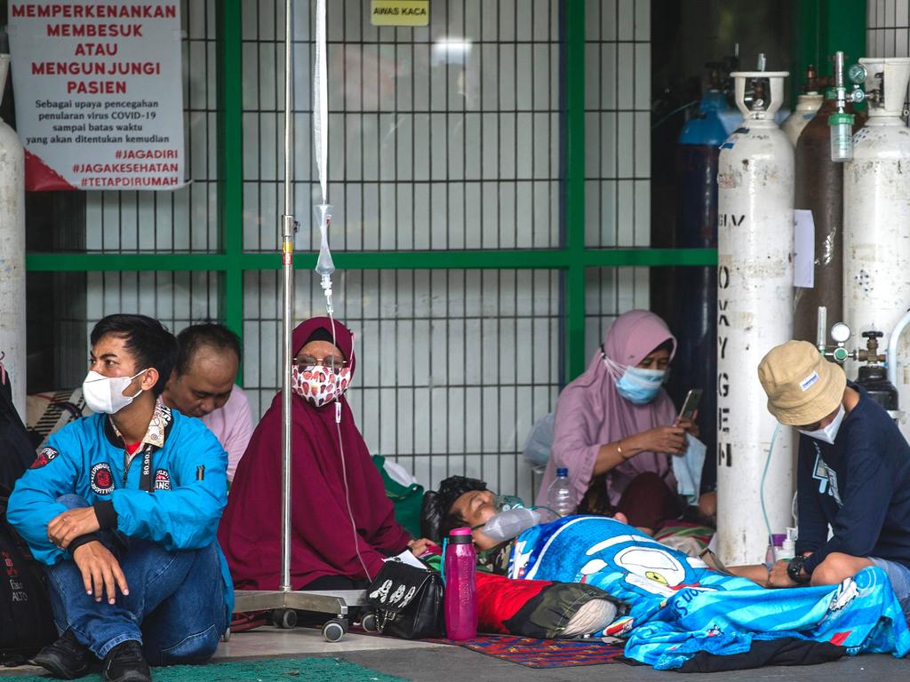 People wait for admission outside the emergency ward of a hospital tending to Covid-19 patients in Surabaya on July 11. Bill Bowtell says it is in Australia’s interests to ensure nations in our region are well vaccinated. Picture: Juni Kriswanto / AFP