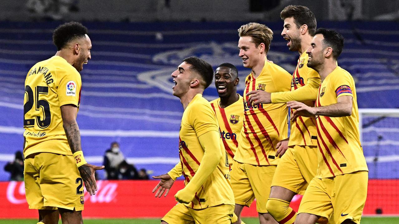 Barcelona's Gabonese midfielder Pierre-Emerick Aubameyang (L) celebrates with teammates after scoring a goal during the Spanish League football match between Real Madrid CF and FC Barcelona at the Santiago Bernabeu stadium in Madrid on March 20, 2022. (Photo by JAVIER SORIANO / AFP)