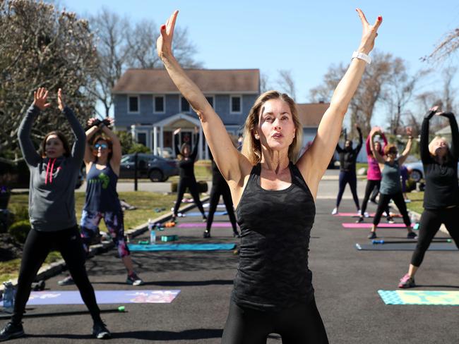 Fitness Instructor Jamie Benedik conducts a fitness class in the driveway of her home on March 26, 2020 in West Islip, New York. Picture: AFP