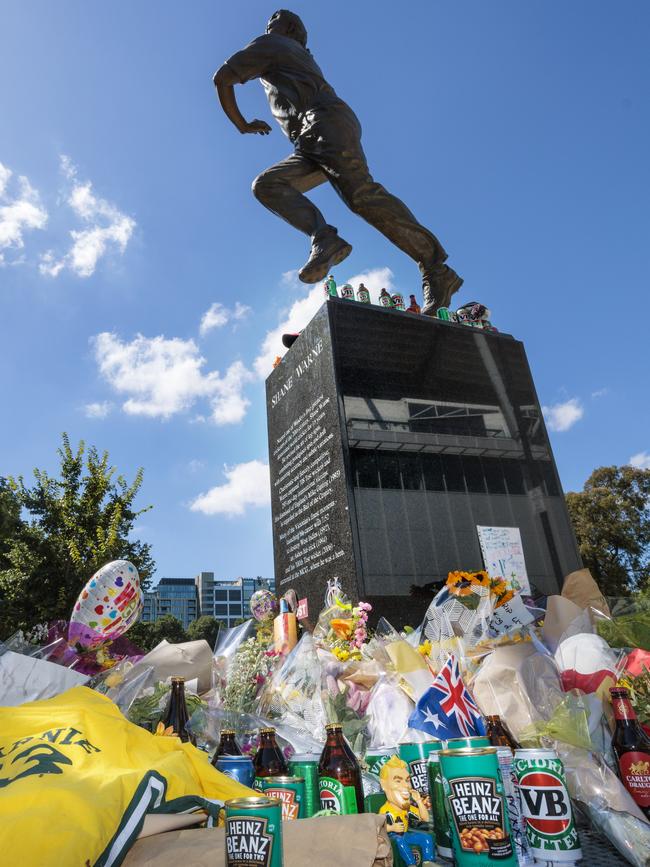 People continue to place flowers and other items at the Shane Warne statue at the MCG days after his death in Thailand. Picture: NCA NewsWire / David Geraghty.