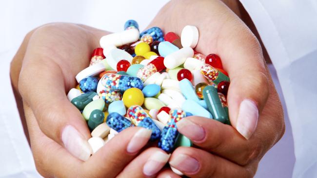 Close-up of vitamins and pills in human hands.